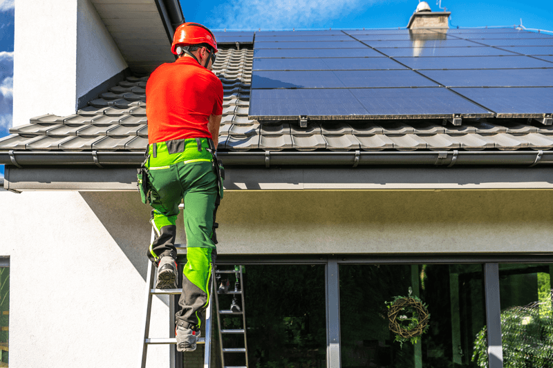 Installatore certificato durante l'installazione dei pannelli solari su un tetto di casa | Abbassalebollette.it Installatore certificato durante l'installazione dei pannelli solari su un tetto di casa